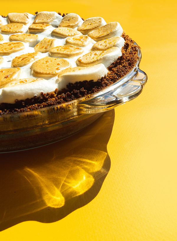 A close-up of a smores pie on a yellow background
