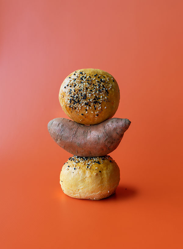 Two hamburger buns balanced together with a sweet potato 