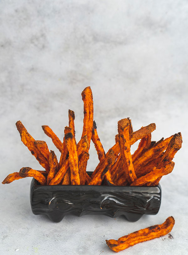 Oven baked sweet potato fries composed inside a small wooden log