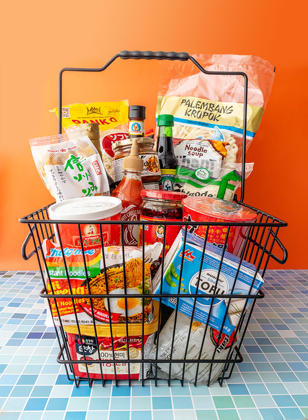 A grocery basket filled with Asian ingredients, supplies, snacks and ready-meals.