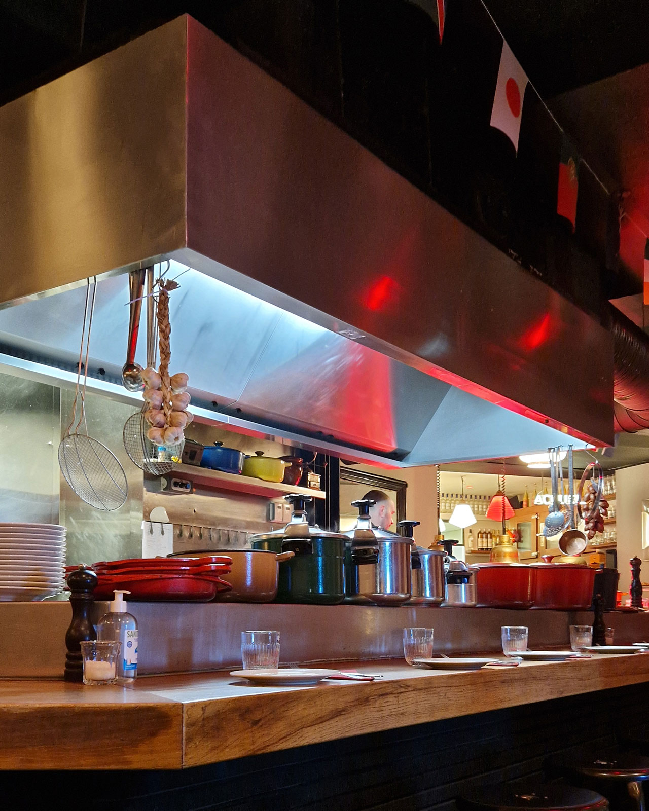 The open kitchen of Au Bistrot, lined with large enamelled pans and pressure cookers.